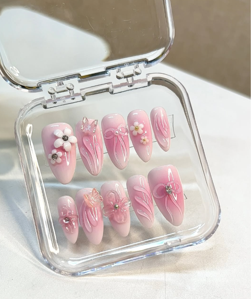 Pink press-on nails with black and white swirl nail art, almond shape – set of 10 in transparent case